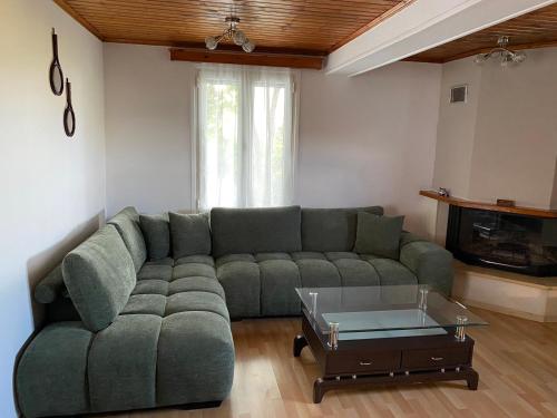 a living room with a green couch and a coffee table at Casa en la Montaña in Kambitsáta