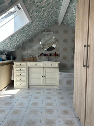 une salle de bain avec un lavabo et un miroir dans l'établissement chambre privé dans un duplex, à Clichy