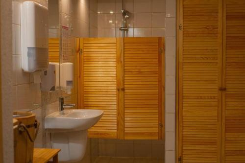 a bathroom with a sink and a toilet with wooden cabinets at Villa FOREST in Poznań