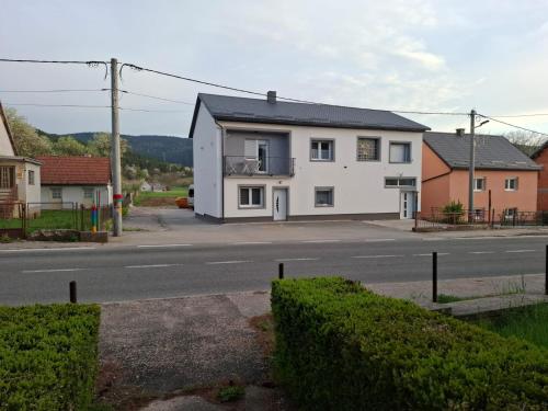 a white house on the side of a street at Villa Natasa near Plitvice for 15 persons in Vrhovine