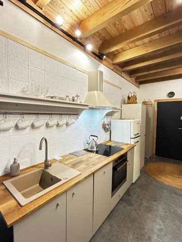 a kitchen with white cabinets and a sink at Szumidomki strefa z jacuzzi sauna widok na potok las in Zawoja