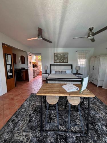 a living room with a bed and a table with a laptop at Cottage at Oceanfront Villa with Pool in East End