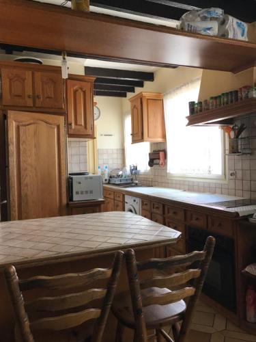 une cuisine avec une table et quelques chaises dans l'établissement chambre privé dans un duplex, à Clichy