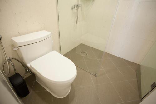 a bathroom with a white toilet and a shower at Puzzlestay House in Seoul