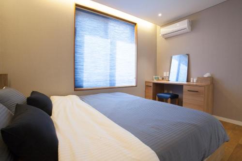 a bedroom with a large bed and a window at Puzzlestay House in Seoul