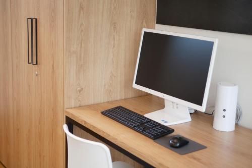 a computer monitor and keyboard on a wooden desk at Puzzlestay House in Seoul