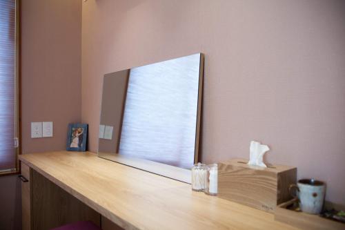 a mirror on a wooden counter in a room at Puzzlestay House in Seoul