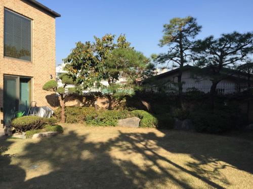 a yard with a house and trees and a building at Puzzlestay House in Seoul