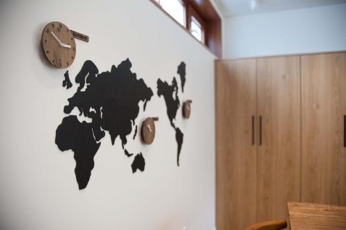 a wall with a clock and a world map on it at Puzzlestay House in Seoul