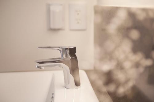 a bathroom sink with a chrome water faucet at Puzzlestay House in Seoul