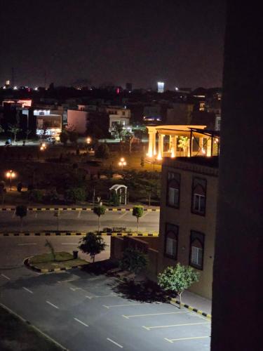 a view of a city at night with a building at StayNova - Transit Apartment near Motorways & Airport in Islamabad