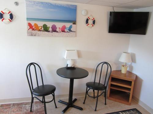 a living room with a tv and a chair at Green Dolphin Motel in Old Orchard Beach