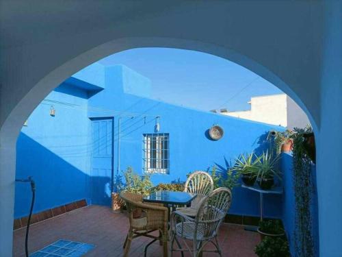a blue walled patio with a table and chairs at Casa Andaluza in Carboneras