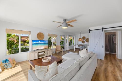 a living room with a couch and a tv at Puamana 111-2 Superior Ocean View in Lahaina