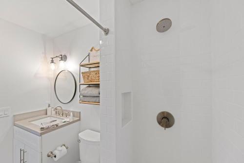 a white bathroom with a sink and a mirror at Puamana 111-2 Superior Ocean View in Lahaina