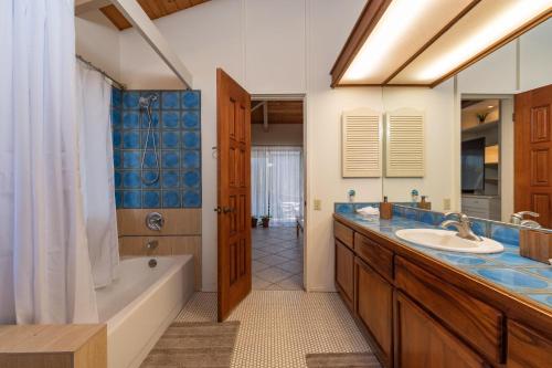 een badkamer met een bad en een wastafel en een ligbad bij Spectacular Oceanfront Home - Honu Hale in Kahana