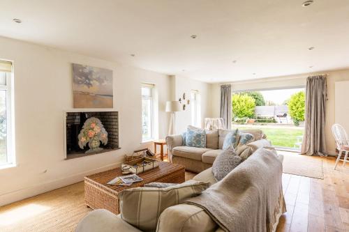 a living room with two couches and a fireplace at 5 Bedroom Family Friendly Beach House - a skip to the water! in West Wittering
