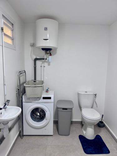 a bathroom with a washing machine and a toilet at Cocon du Souffleur in Port-Louis