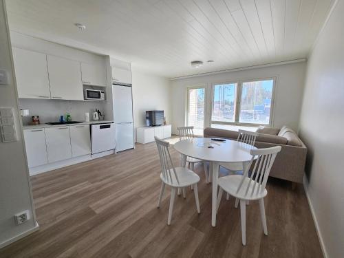 un soggiorno con tavolo e sedie e una cucina di Heim Apartments - Rivitalo a Seinäjoki