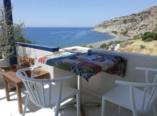 a table and chairs on a balcony with a view of the ocean at Endless Blue Studios in Myrtos