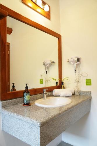 a bathroom counter with a sink and a mirror at Hotel Claroscuro Casa Ilayaku in Guangopolo