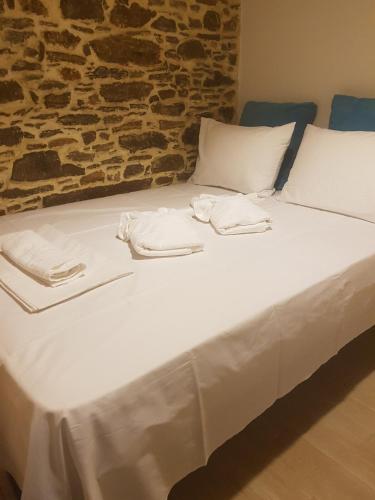 a large bed with white sheets and towels on it at The Weaver's house in Kithnos