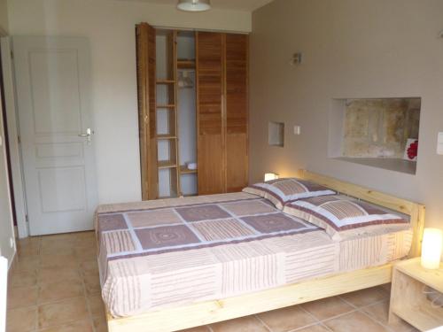 een slaapkamer met een groot houten bed in een kamer bij La grange in Saint-Germain-de-Lusignan