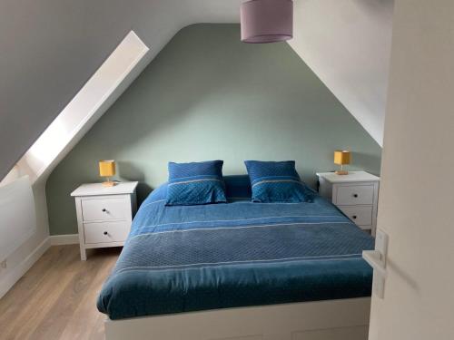 - une chambre avec un lit doté de draps bleus et d'oreillers bleus dans l'établissement Charmante maison proche de la mer à Locquémeau, à Locquémeau