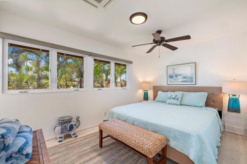 Un dormitorio con una cama y un ventilador de techo. en Puamana 87-2 Premium Garden View, en Lahaina