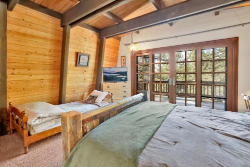 Un dormitorio con una cama grande en una habitación con paredes de madera. en Relaxing Big Cub Cabin at Big Bear, en Big Bear Lake