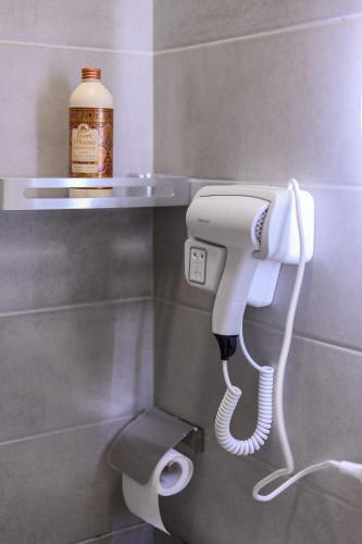 a white phone in the corner of a bathroom at Keis Apartments in Tirana