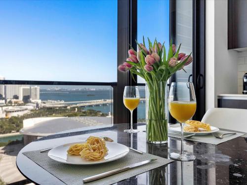 a table with two plates of pasta and two glasses of wine at MVR Miami s Top Stay Views for Days in Miami