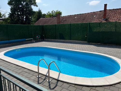 a large blue swimming pool in a backyard at Vip House 2 in Vrnjačka Banja