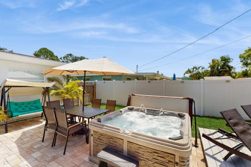 een hot tub op een patio met een tafel en stoelen bij Bermuda Oasis in Seminole