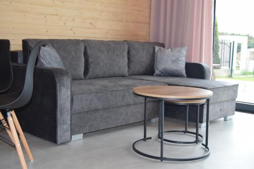 een woonkamer met een bank en een tafel bij Domki Morskie Jastrzębia Góra - Domki z basenem in Jastrzębia Góra