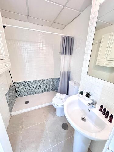 a bathroom with a sink and a toilet and a shower at Apartamento Empul Rota Príncipe in Rota