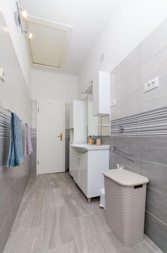 a white bathroom with a sink and a toilet at Apartment Kokic in Zastražišće