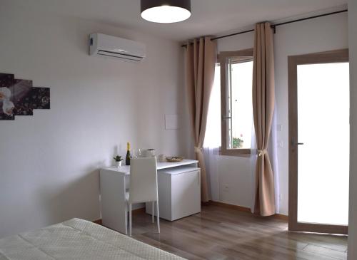 a white room with a desk and a window at Affittacamere Lumal 604 in Domus de Maria