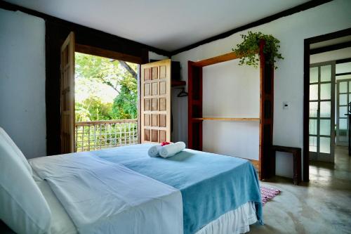 a bedroom with a bed with two towels on it at Vila Cizinho in Itaúnas