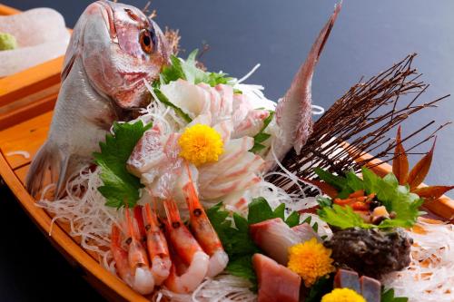 a plate of food with a fish and vegetables at Amanohashidateso in Miyazu