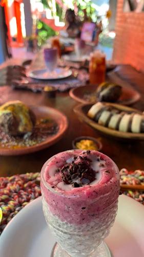un vase en verre avec un dessert rose dedans sur une table dans l'établissement Pousada Bem-Viver na Vila de Itaúnas, à Itaúnas