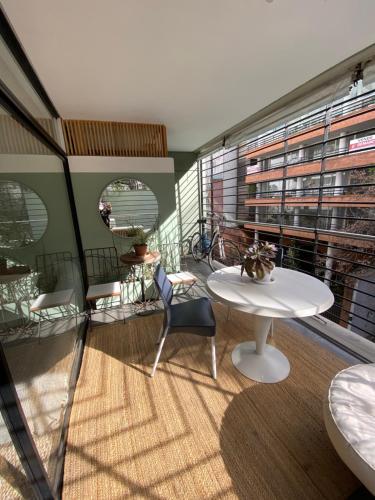 Habitación con mesa blanca, sillas y ventana en Belgrano-3A, en Buenos Aires