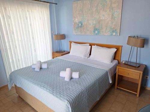 a bedroom with two white towels on a bed at Maria Apartments in Paralia Dionysiou