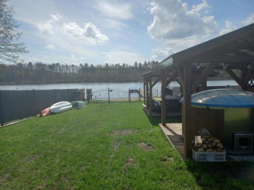 a house with a gazebo next to a lake at Kubusiowy Zakątek in Ełk