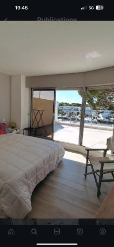 une chambre avec un lit et une grande fenêtre dans l'établissement superbe marina à Port Camargue, au Grau-du-Roi