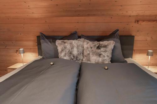 a bed with two pillows in a room with wooden walls at Ferienwohnung Holzegger in Hart im Zillertal
