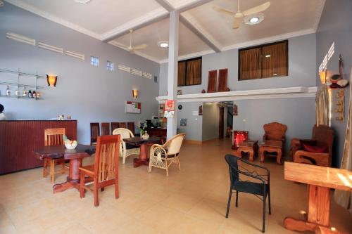 a living room with tables and chairs and a kitchen at Cheng Lay Guesthouse in Siem Reap