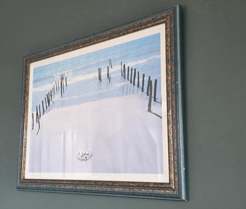 a picture of a beach in a frame on a wall at The Steam Packet in Littlehampton