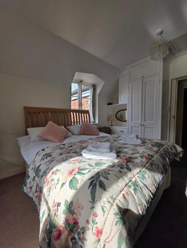 a bedroom with a large bed with a floral bedspread at The Steam Packet in Littlehampton