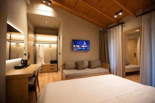 a bedroom with a bed and a couch in a room at Montis Agroturizëm Hotel Spa in Kaninë